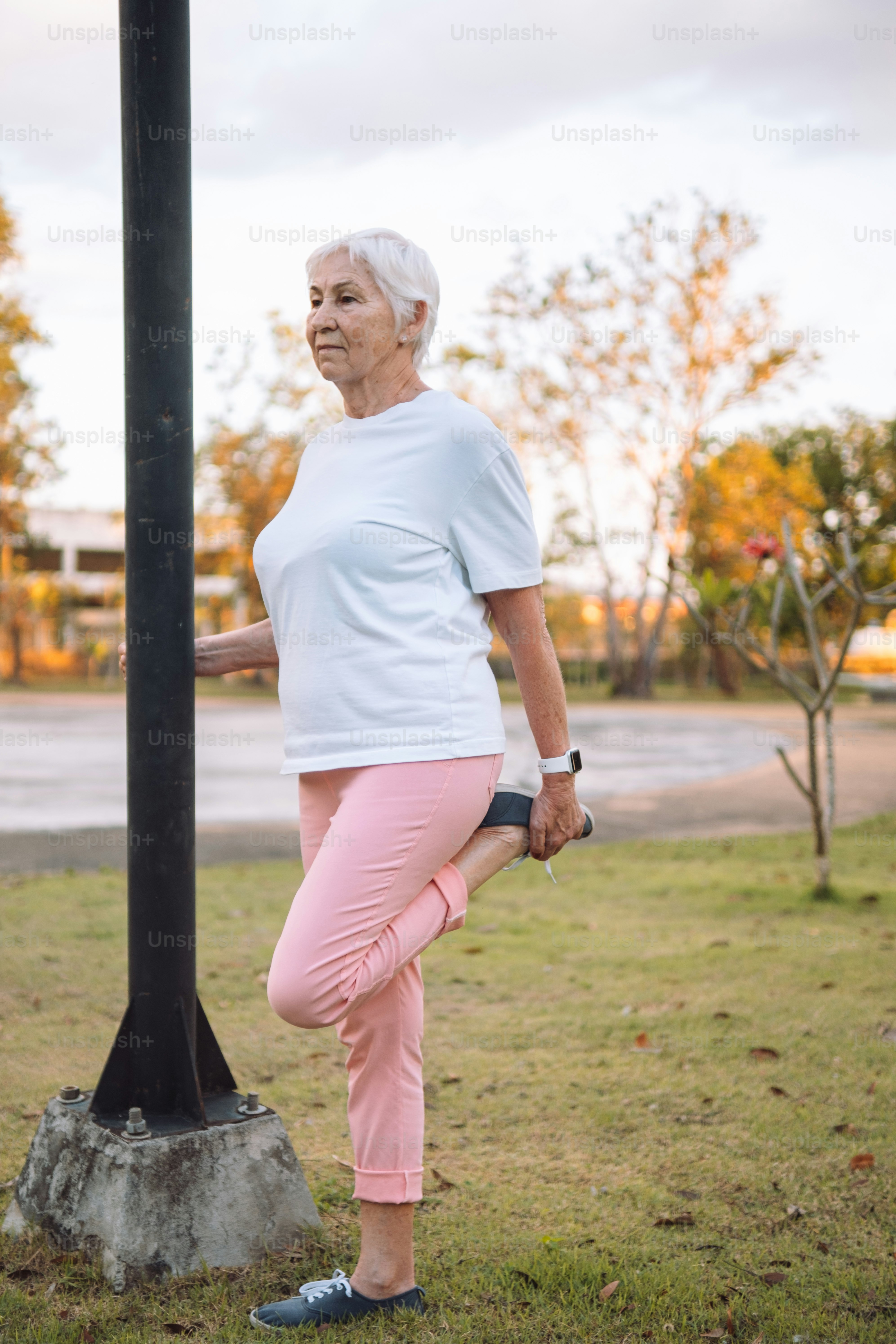 a woman in pink pants standing next to a pole