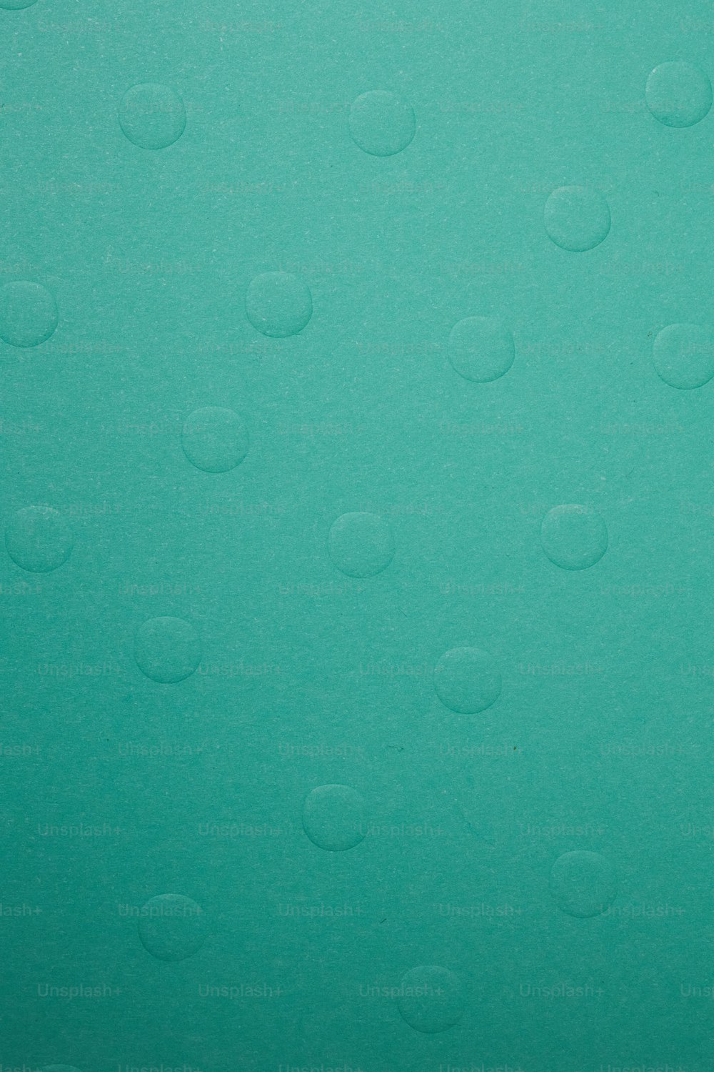 a close up of water droplets on a green surface