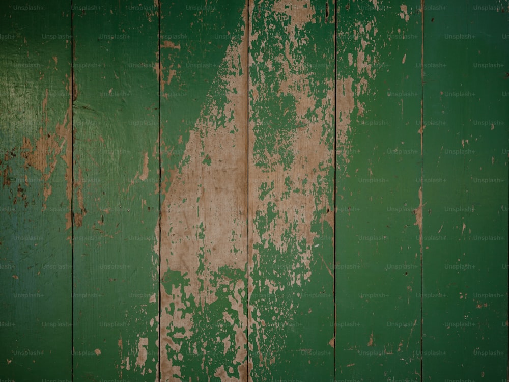 un mur vert avec de la peinture écaillée dessus