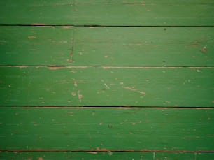um close up de uma parede de madeira verde com tinta descascando