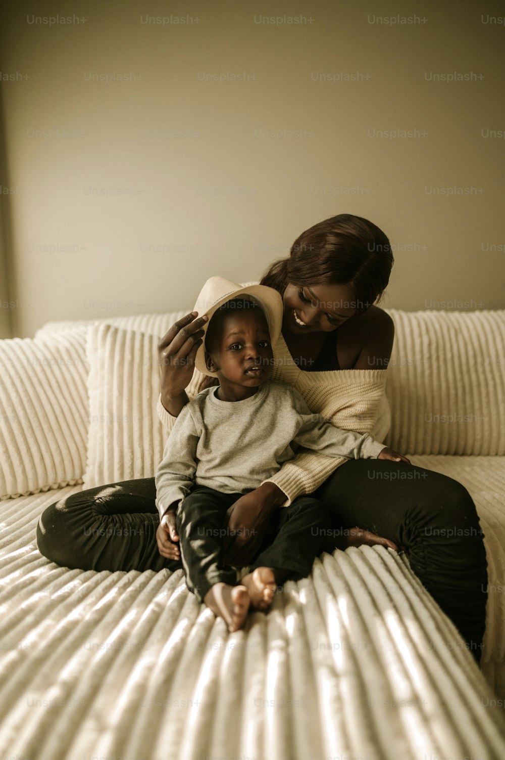 a woman and a child sitting on a bed