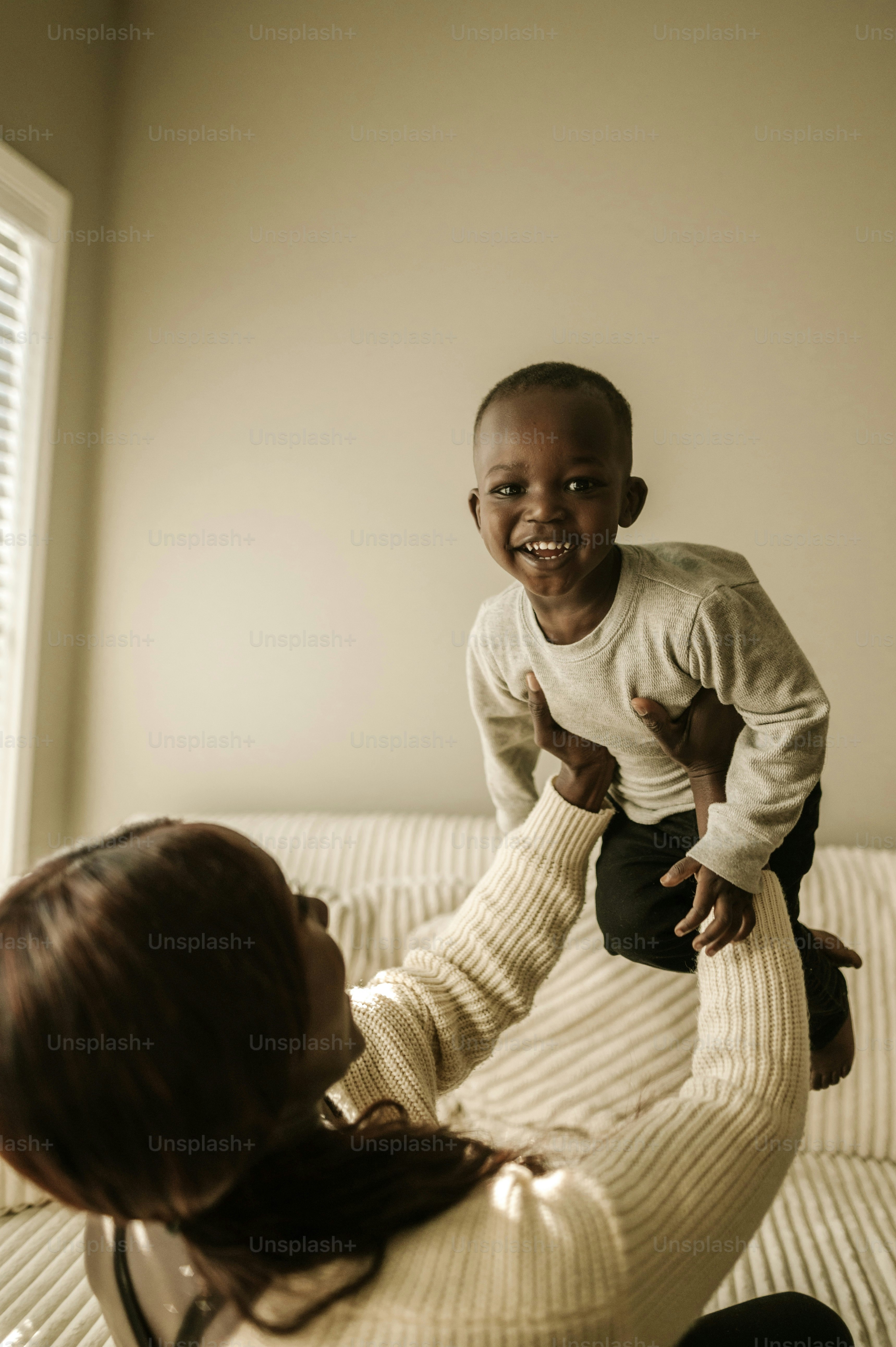 a woman sitting on top of a bed next to a child