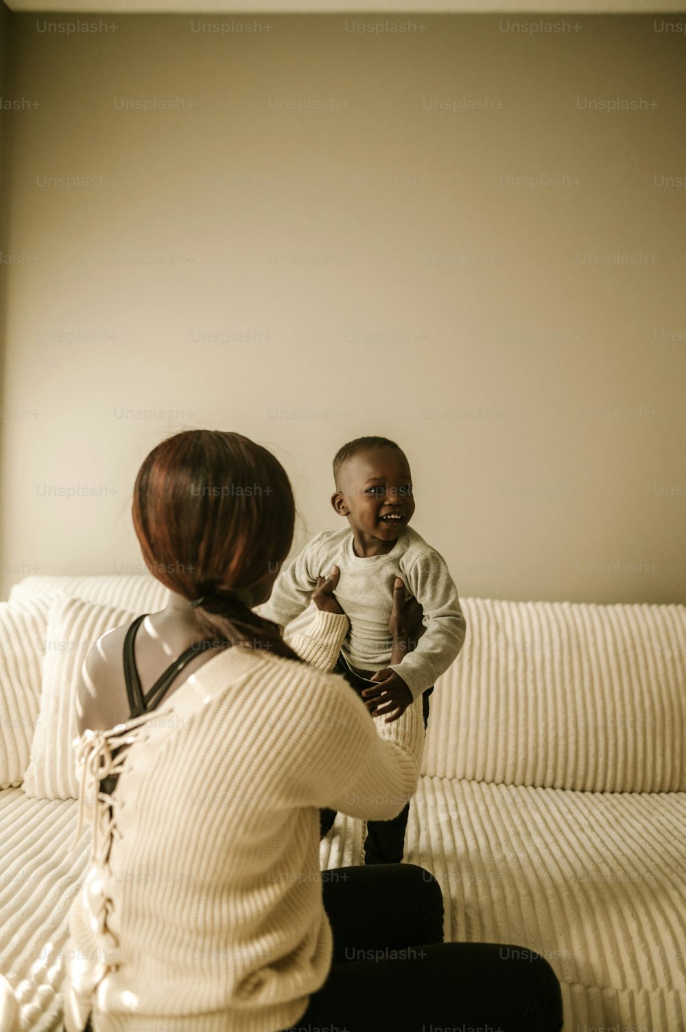 a woman sitting on a couch holding a baby