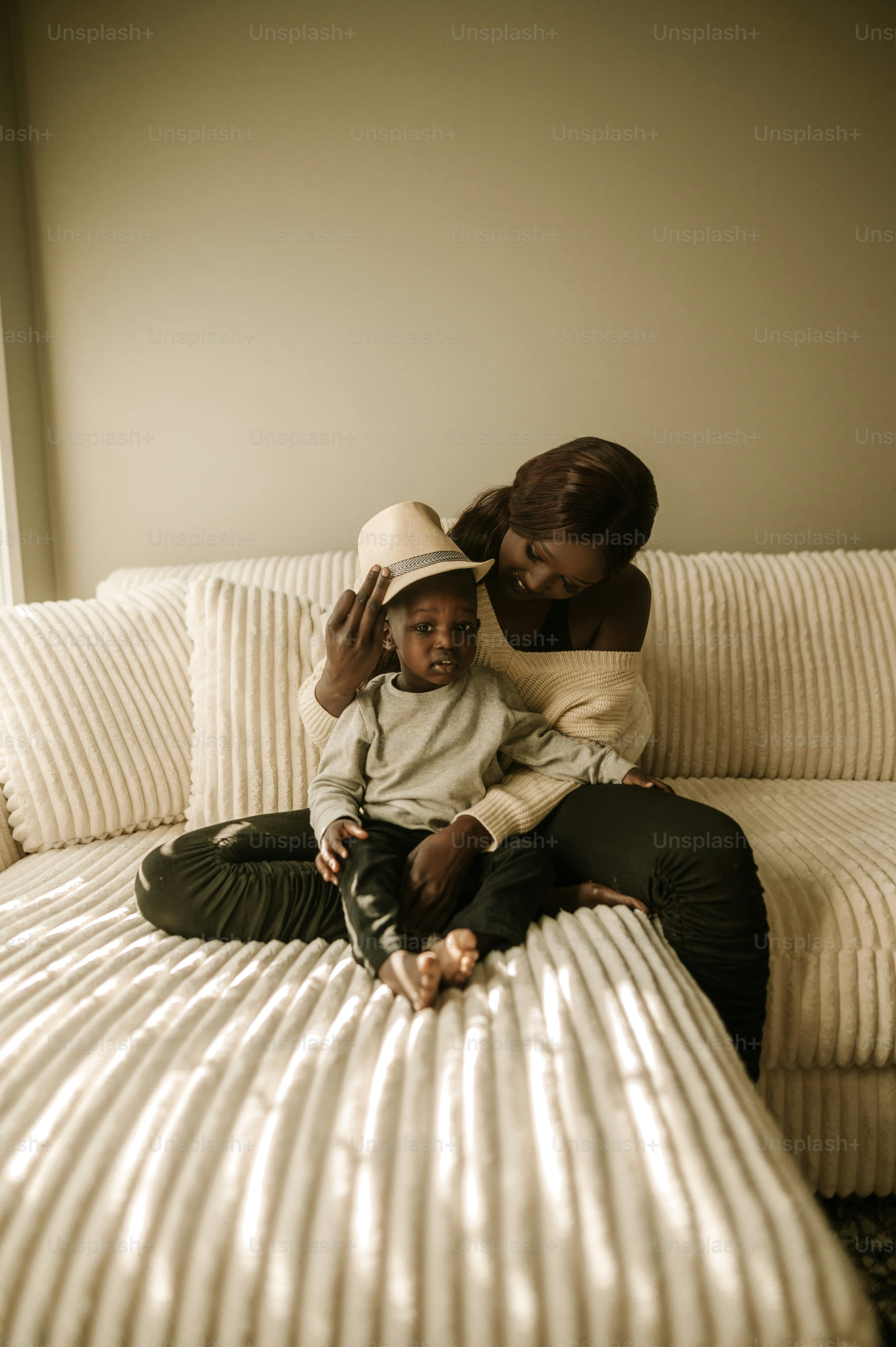 a woman sitting on top of a bed next to a child