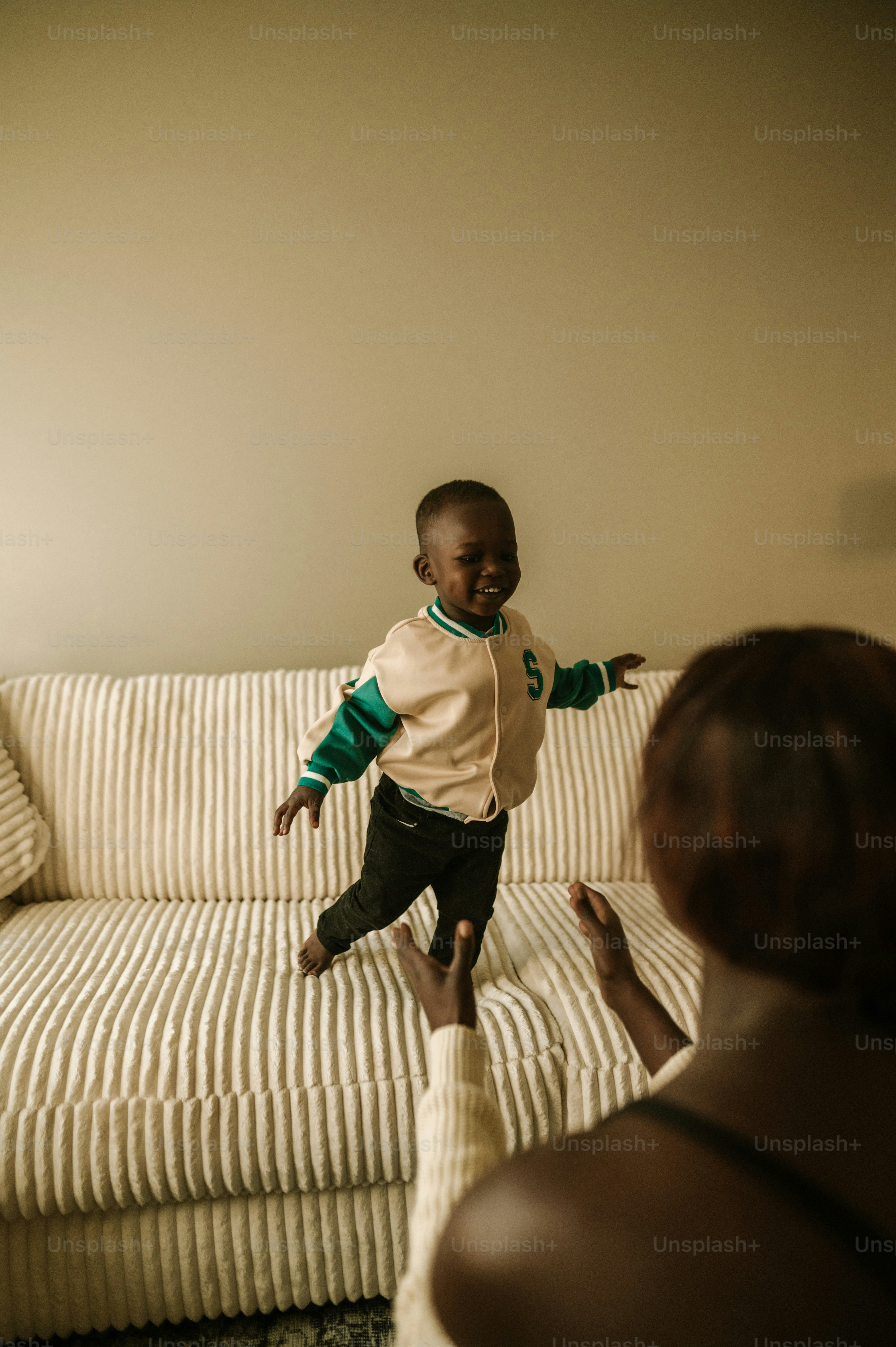a woman holding a baby in front of a couch