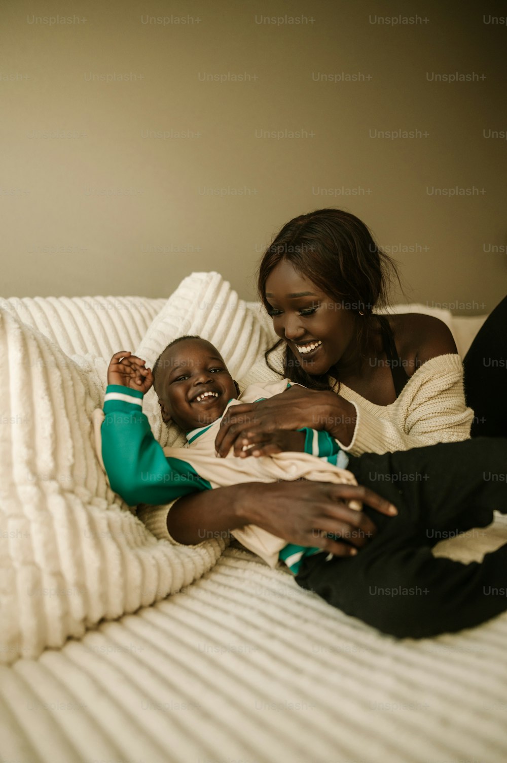 Una mujer sosteniendo a un niño encima de una cama