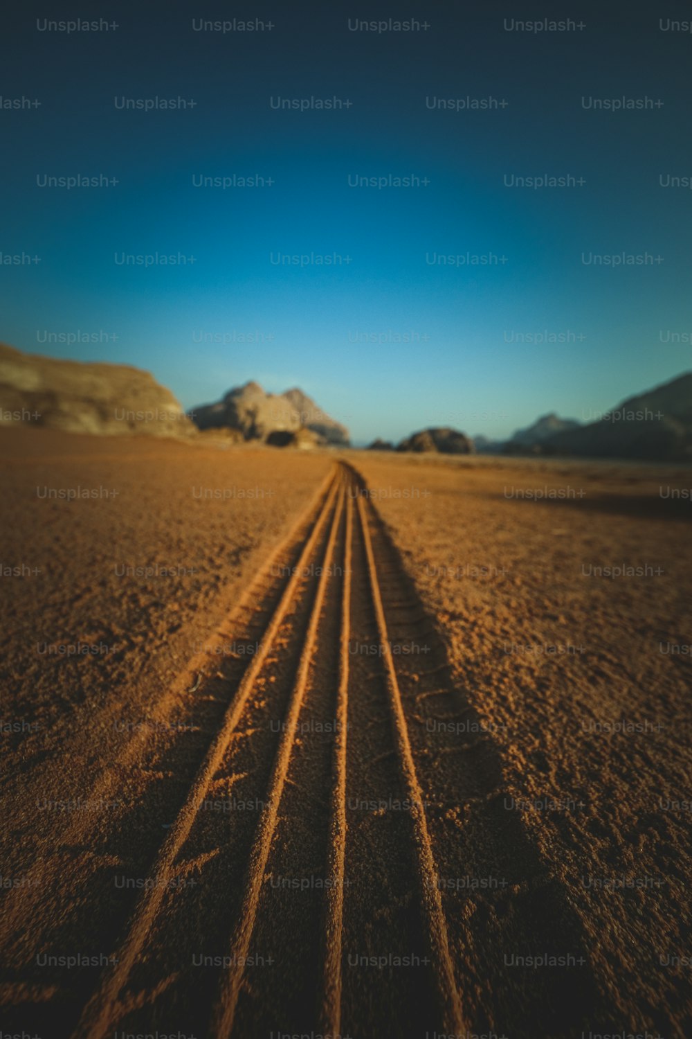 a long line of tire tracks in the desert