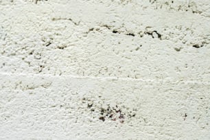 Un idrante rosso seduto di fronte a un muro bianco