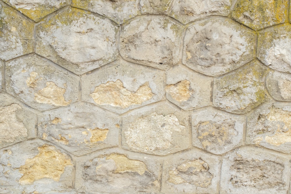 um close up de uma parede de pedra com tinta amarela