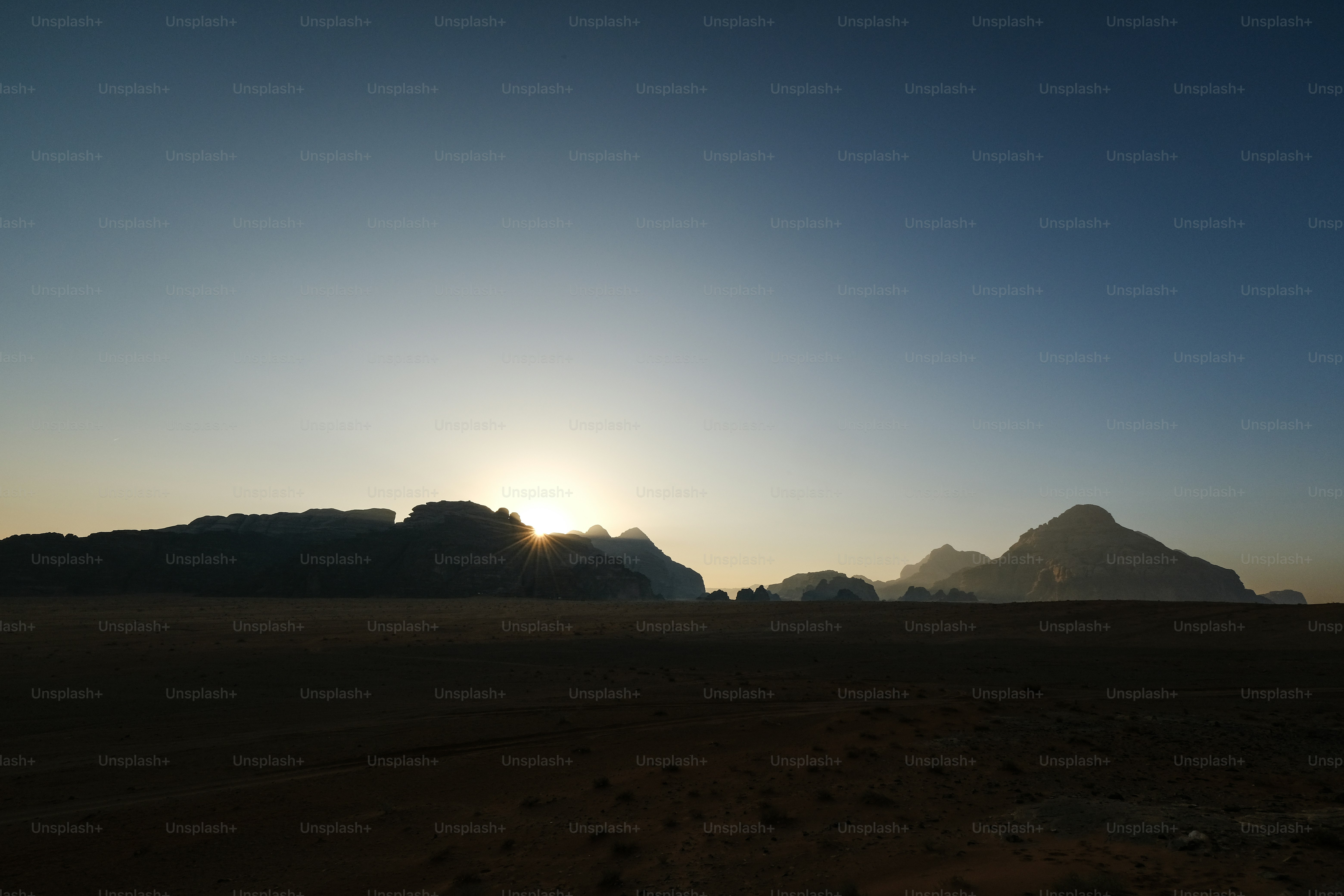 The sun is setting over the mountains in the desert photo – Sunset ...