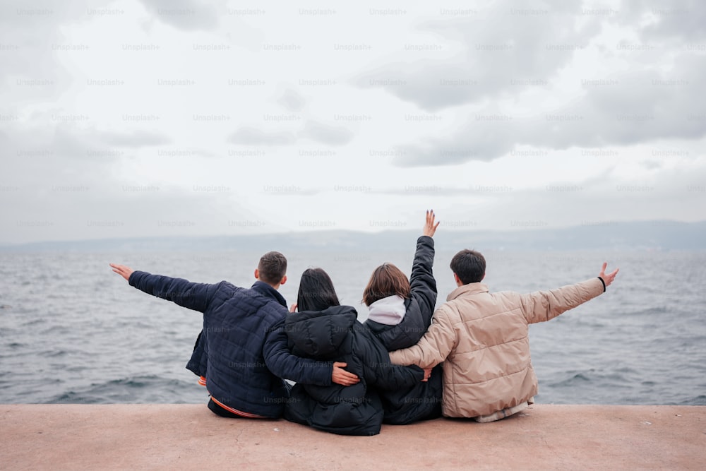 a group of people sitting on top of a pier