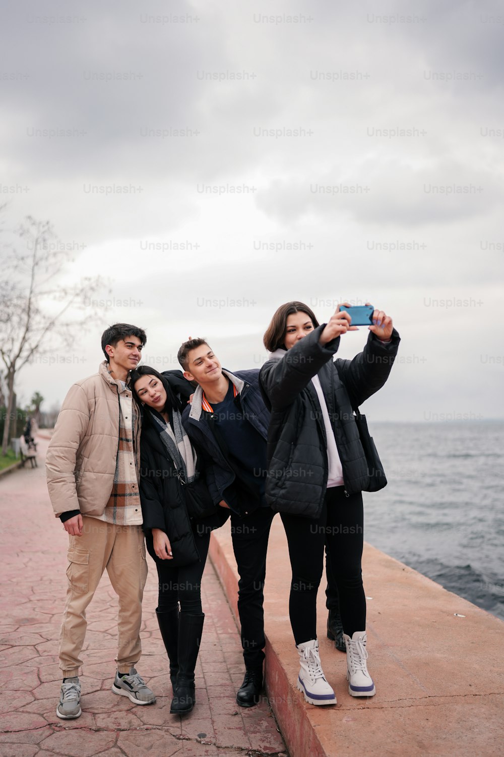 a group of people taking a picture with a cell phone