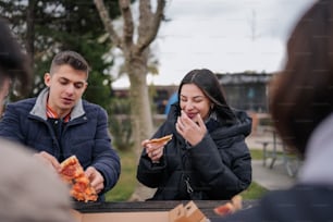 a man and a woman eating pizza together