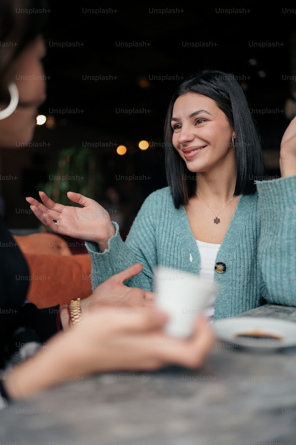 una donna seduta a un tavolo che parla con un'altra donna