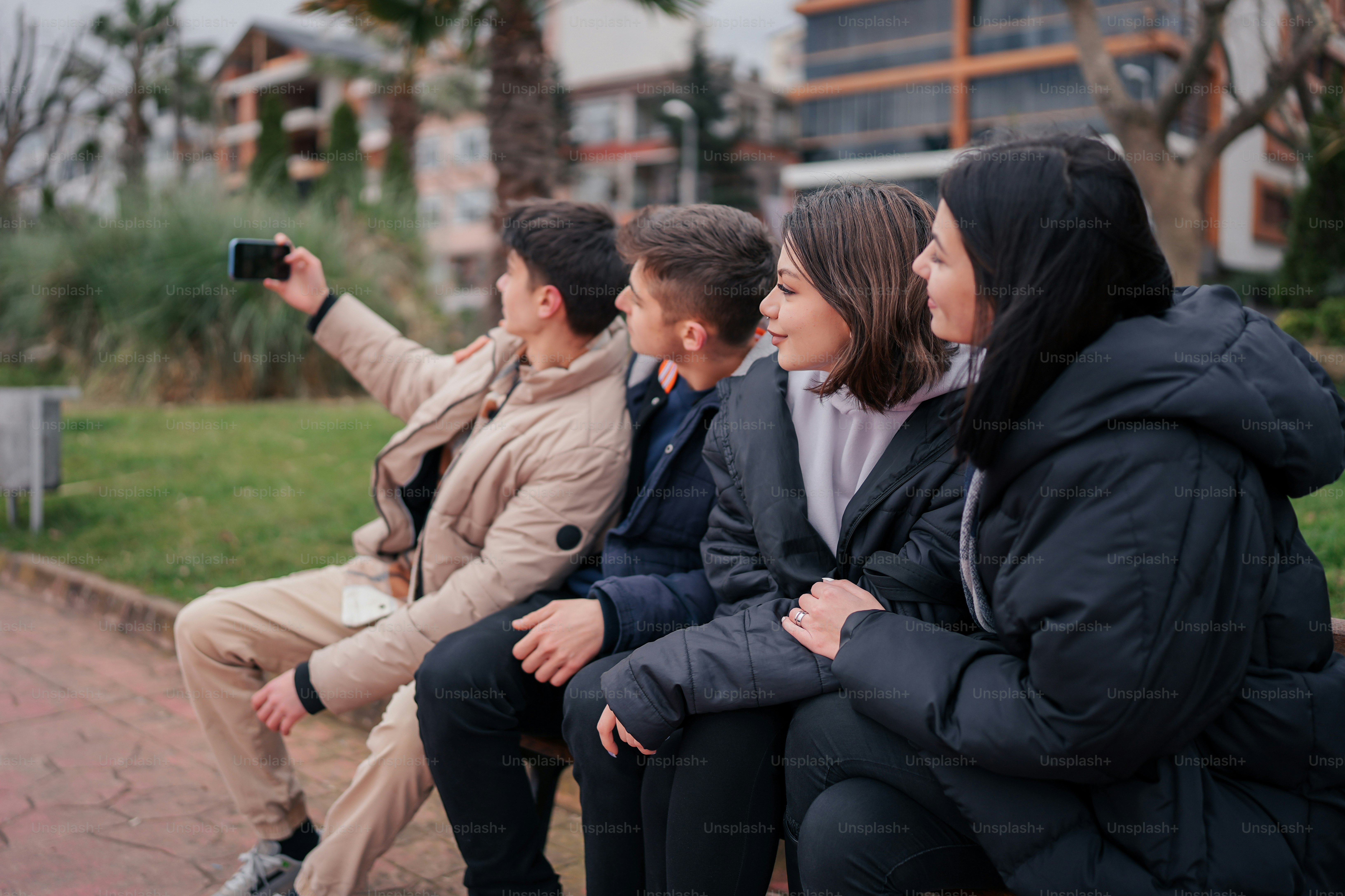 a group of people sitting on top of a wooden bench