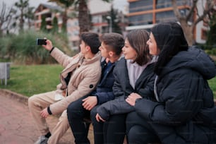 um grupo de pessoas sentadas em cima de um banco de madeira