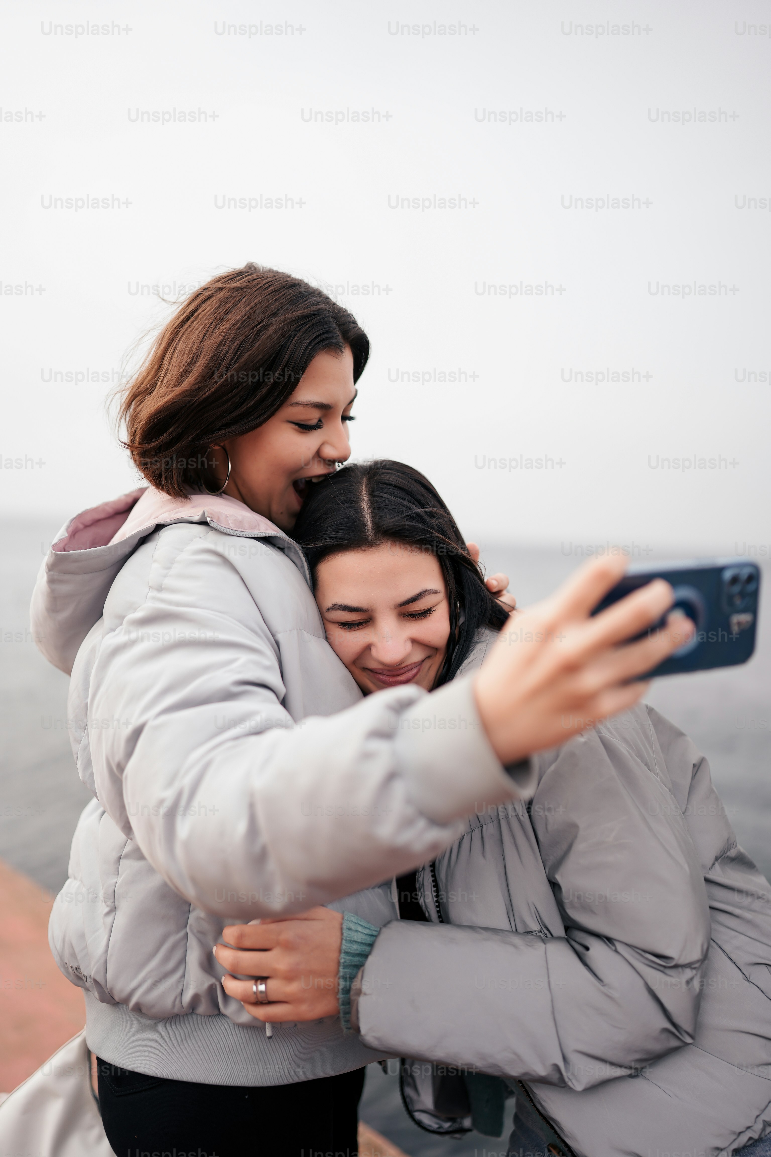 two women taking a picture with a cell phone