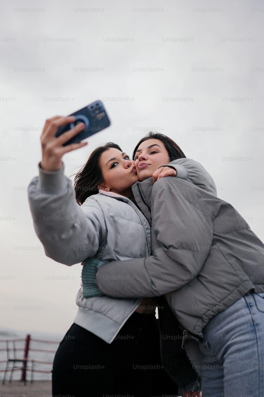 휴대폰으로 사진을 찍는 두 여자