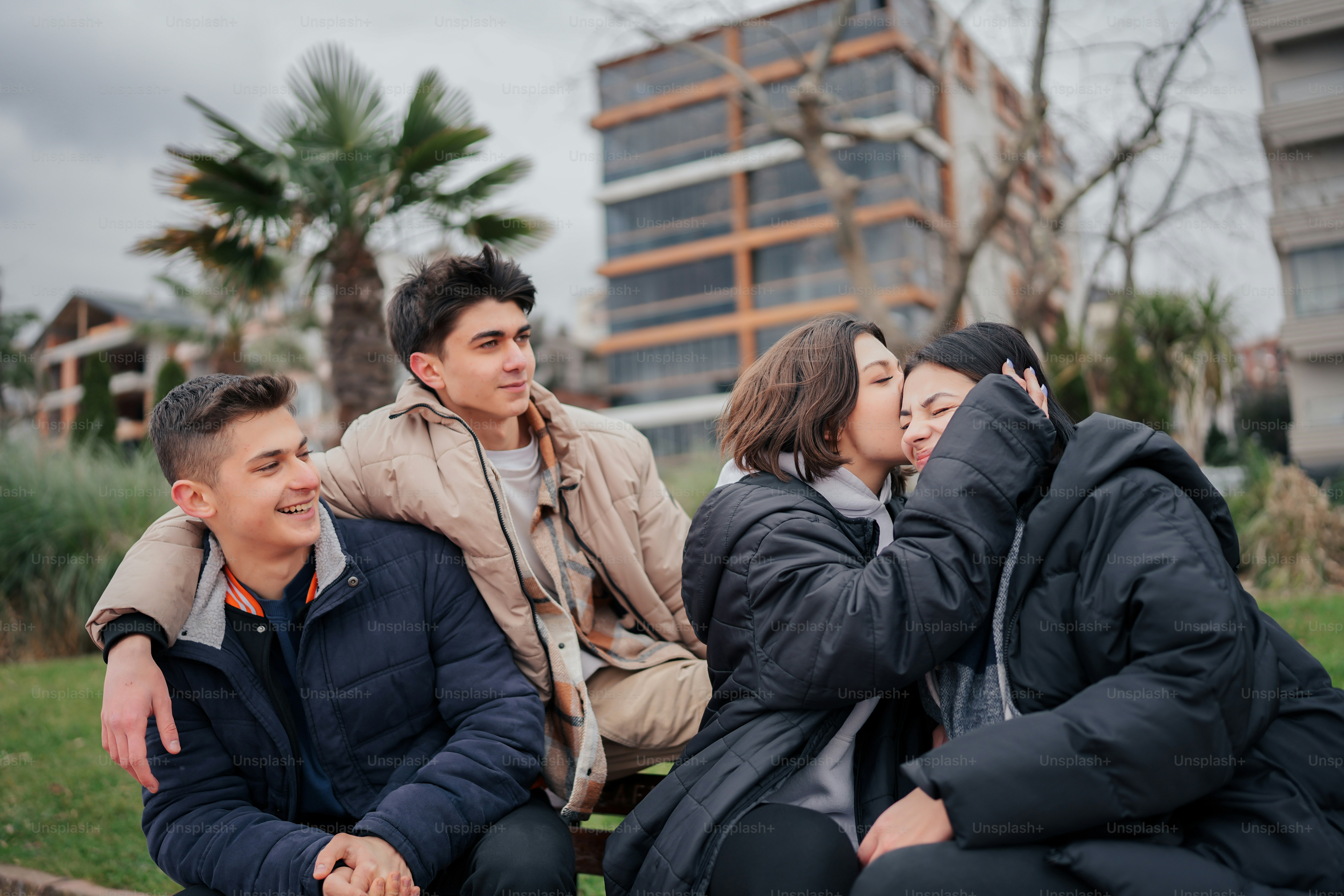 a group of people sitting on top of a wooden bench