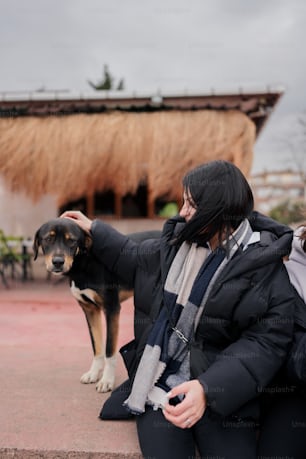 a woman petting a dog on the nose