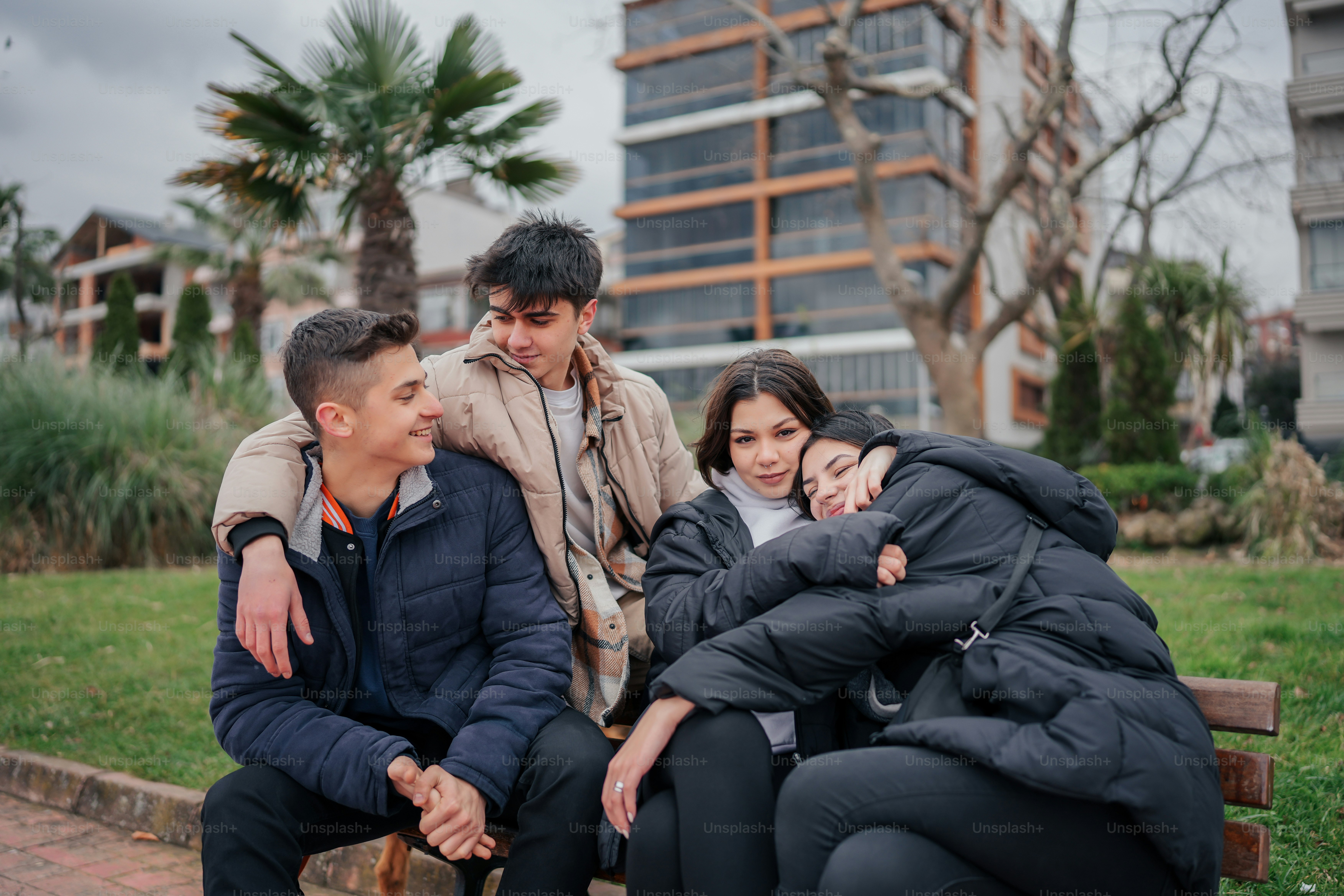a group of people sitting on top of a wooden bench
