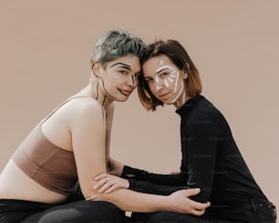 two women sitting next to each other posing for a picture
