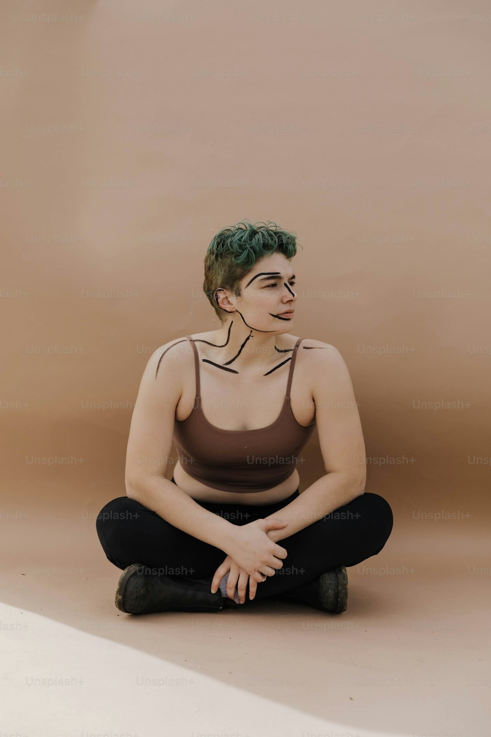une femme aux cheveux verts assise par terre