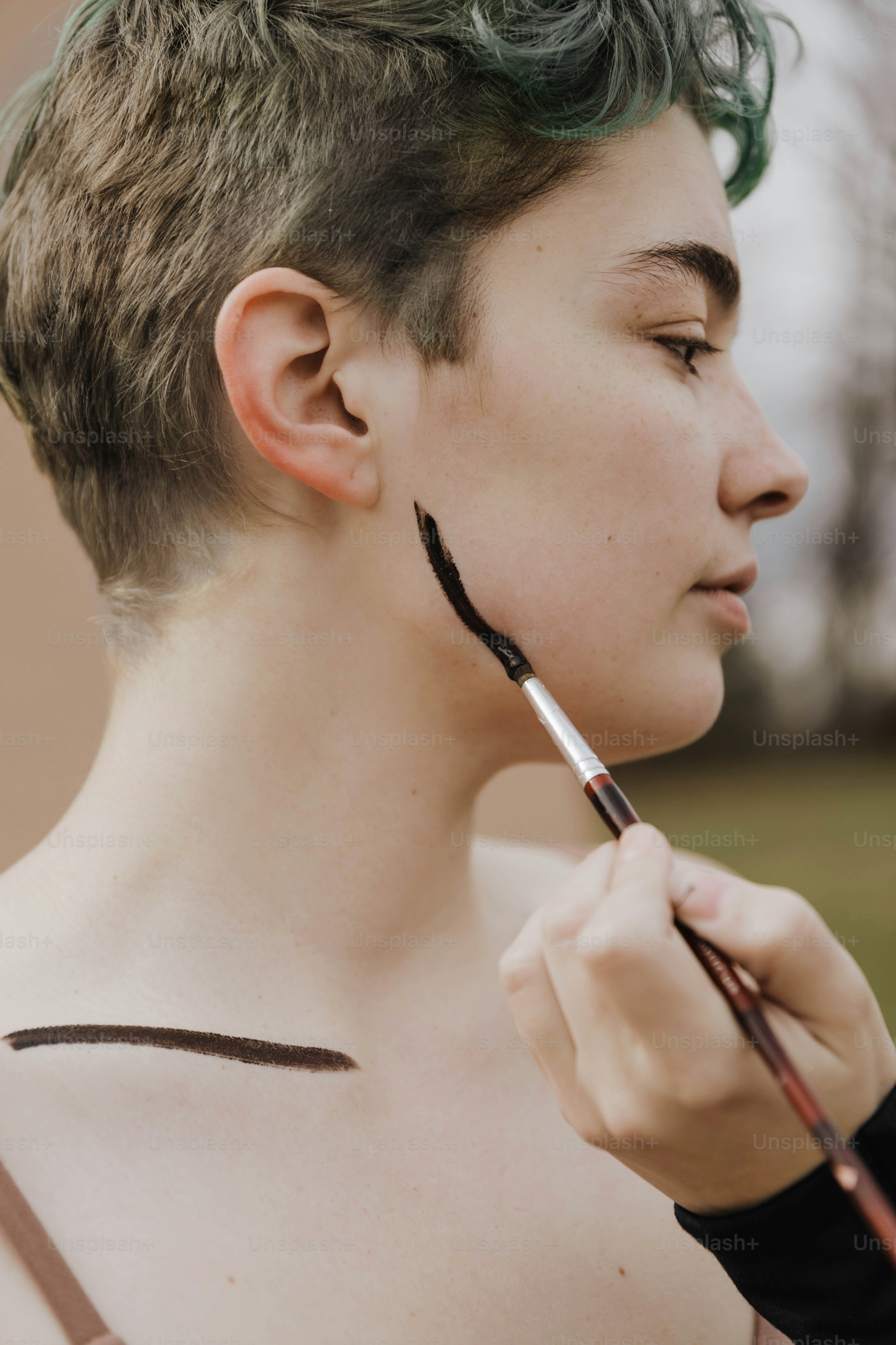 Une femme aux cheveux verts tient une brosse