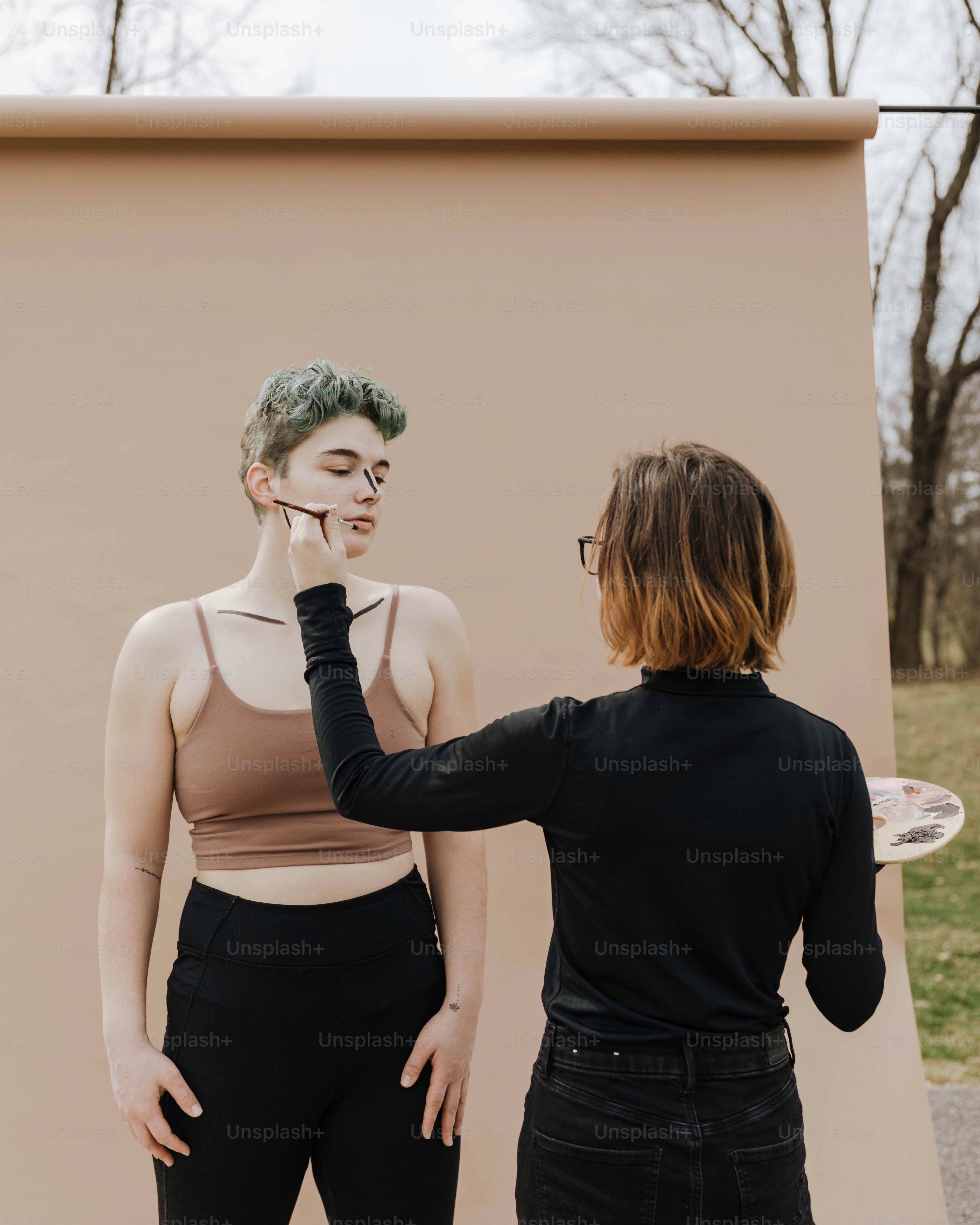 a woman standing next to a woman with a frisbee