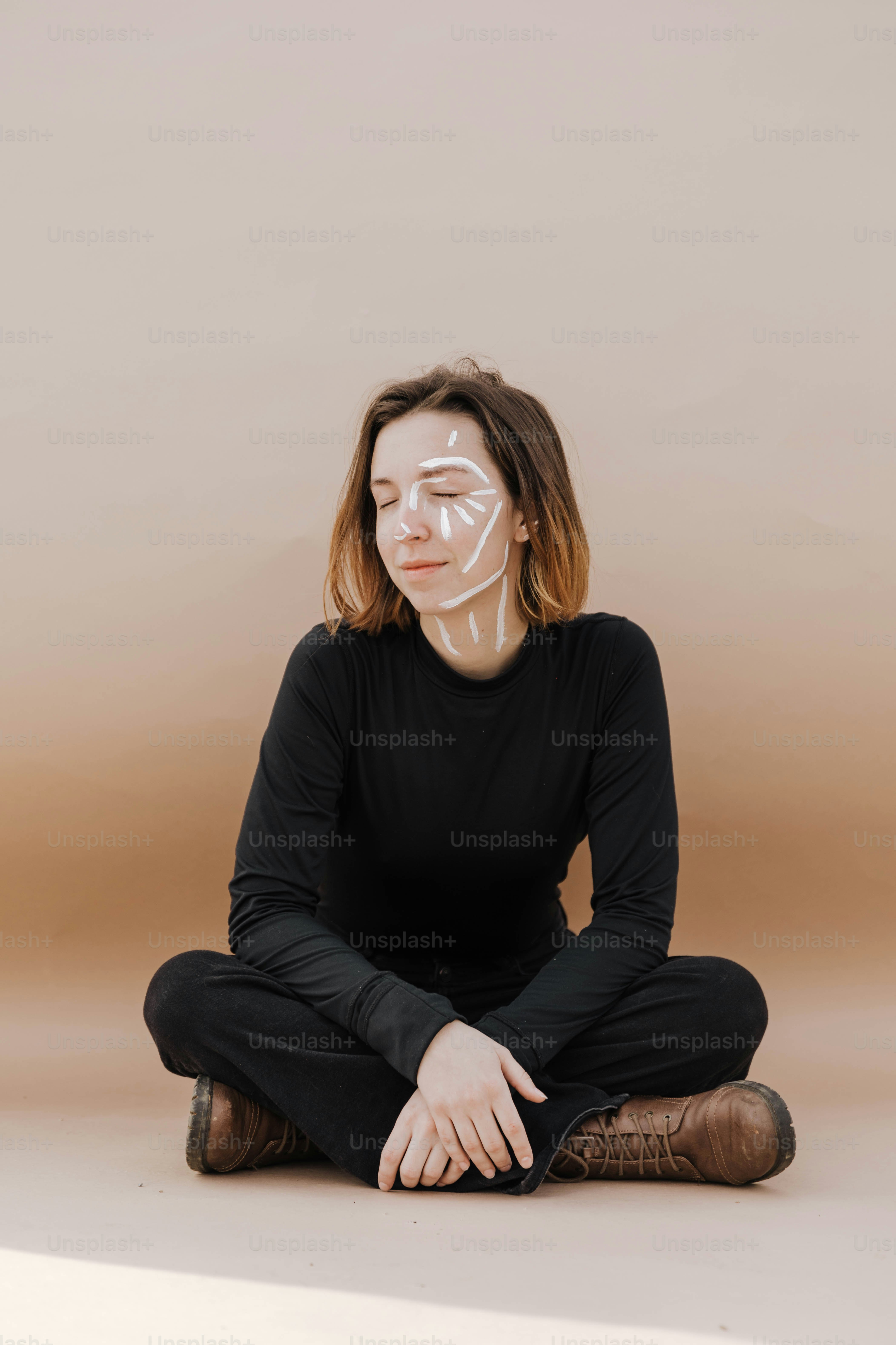 a woman sitting on the floor with a mask on her face