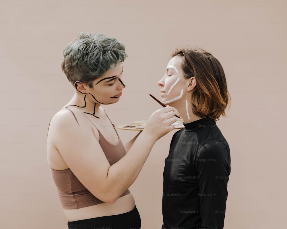 a woman is putting a mask on another woman's face