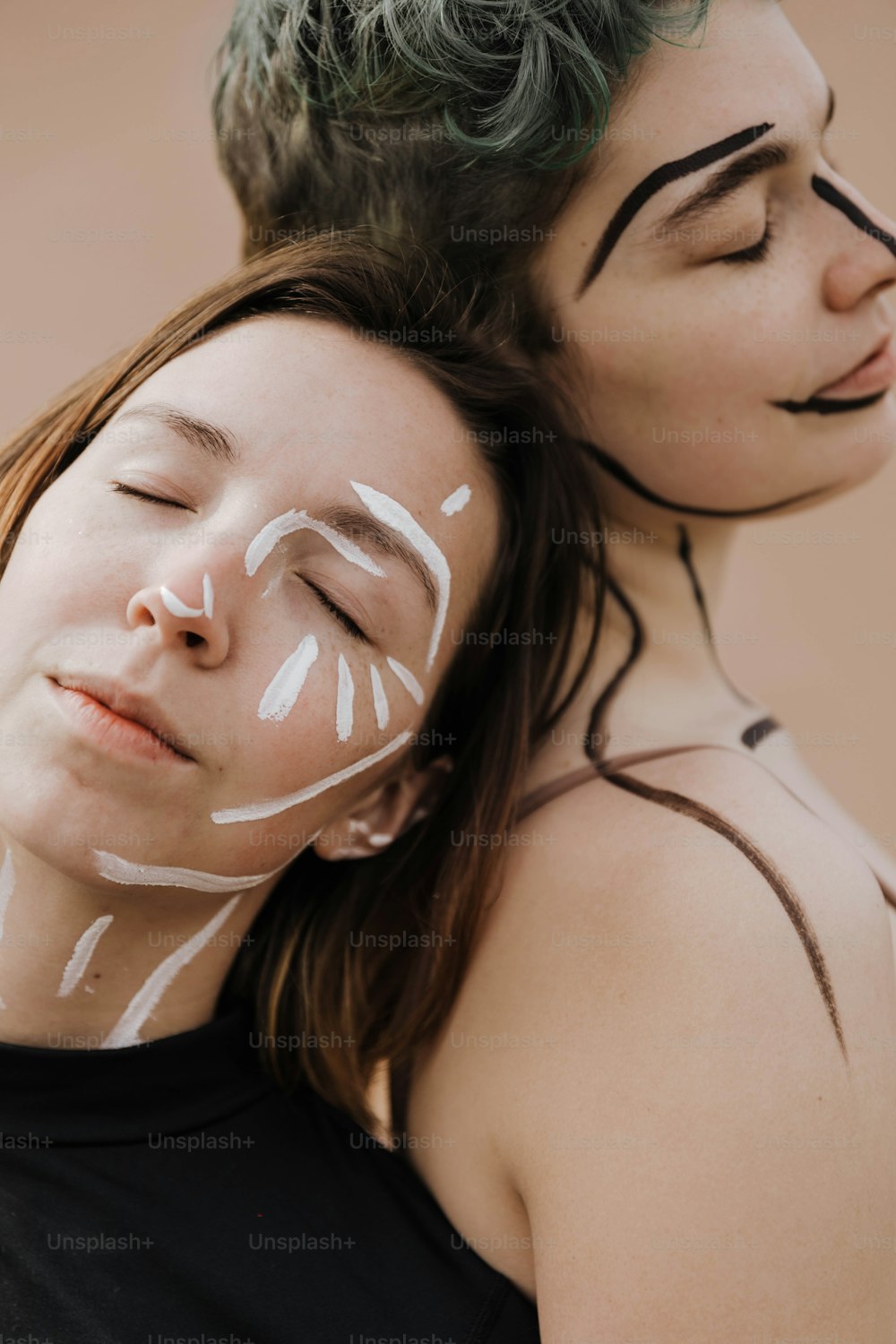 얼굴에 얼굴 페인트를 칠한 두 명의 여성