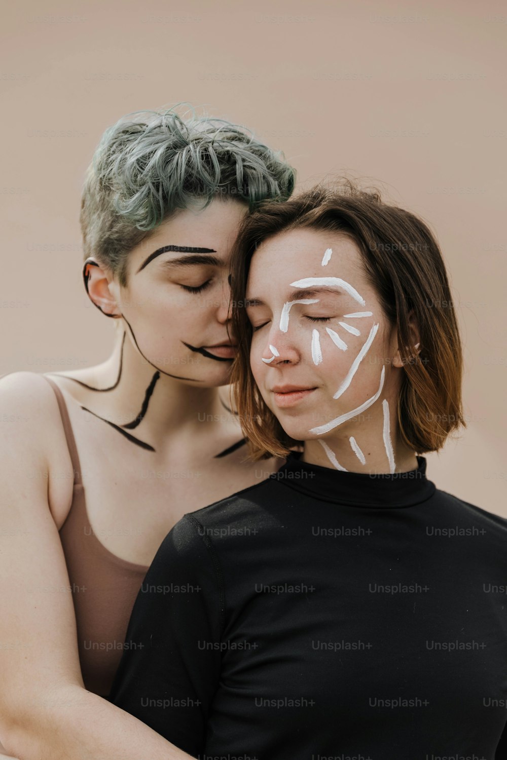 two women with painted faces hugging each other