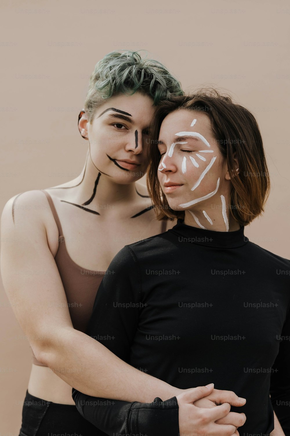 two women with painted faces hugging each other