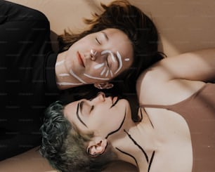 a man and a woman with face paint laying on the ground