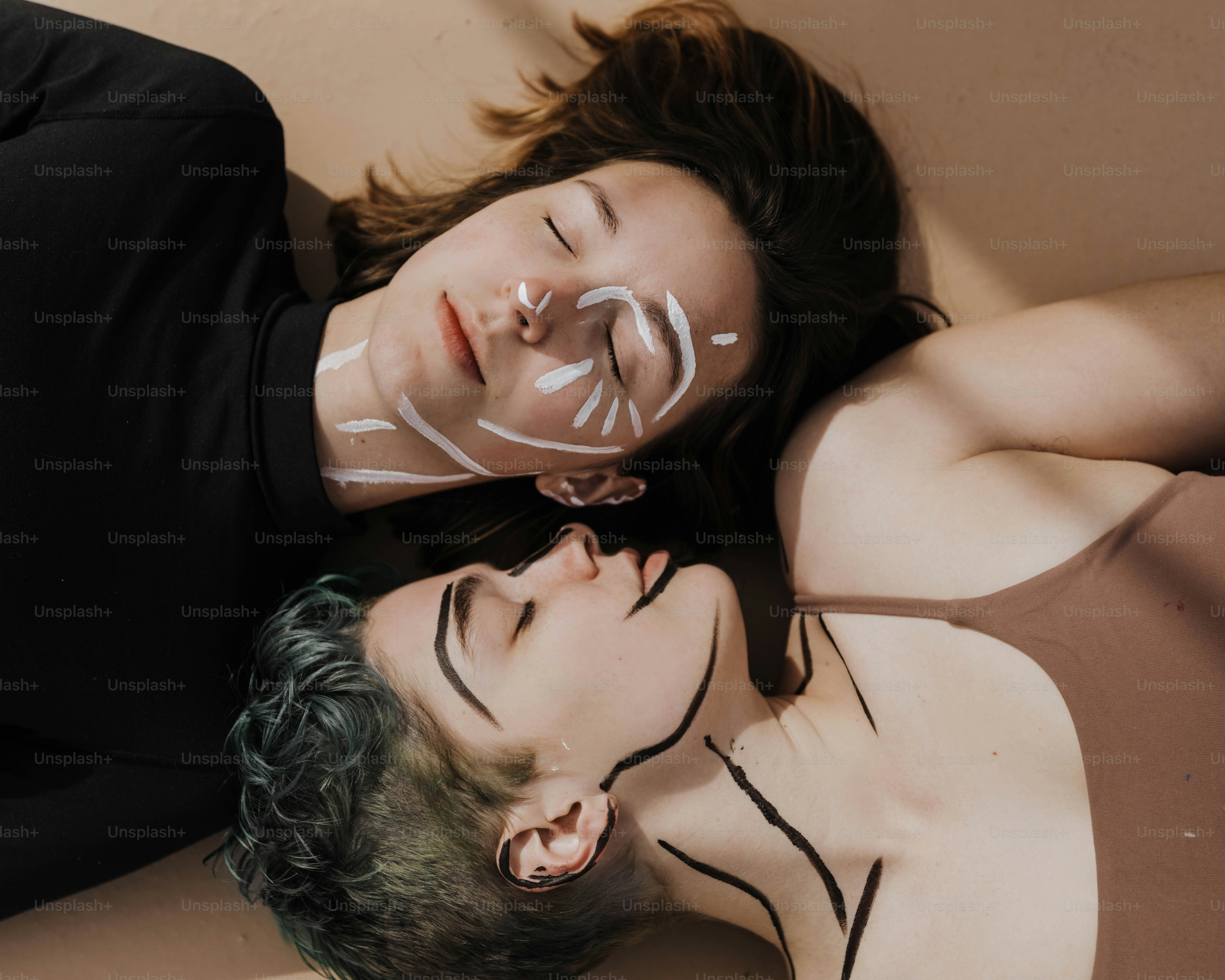 a man and a woman with face paint laying on the ground