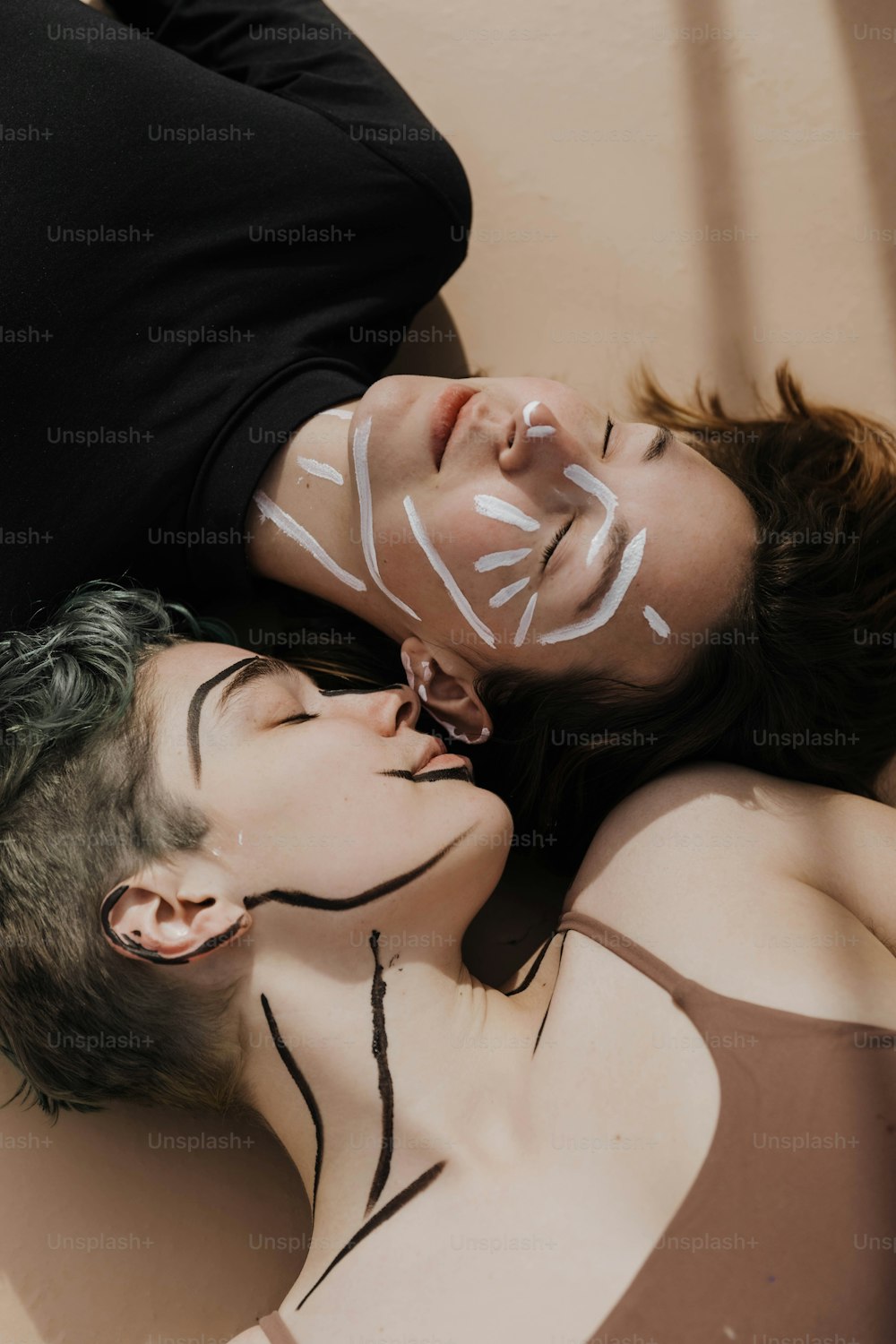 얼굴을 칠한 채 땅에 누워 있는 남자와 여자