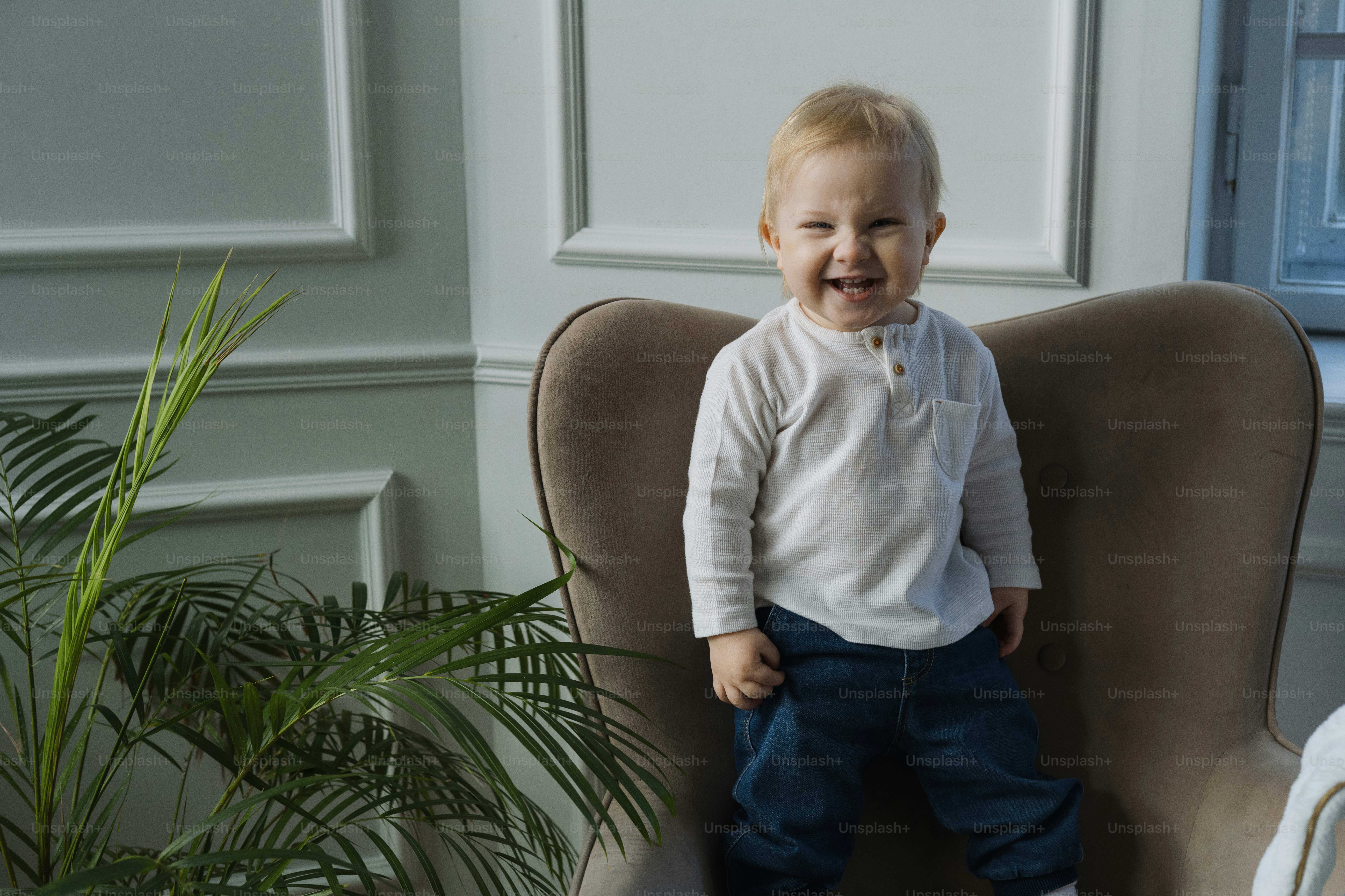 Un petit garçon assis sur une chaise avec un sourire sur son visage