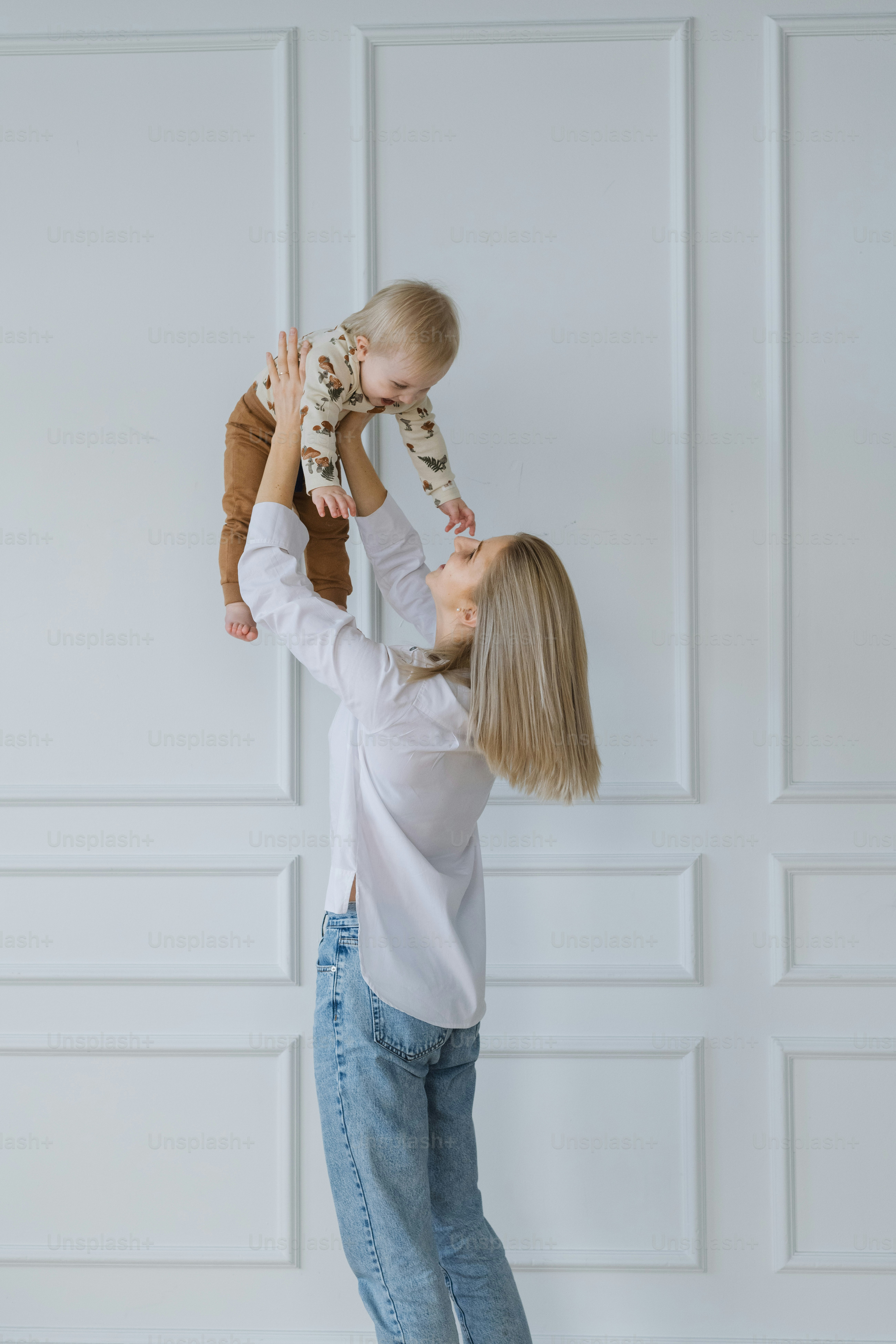 Une femme tenant un bébé en l’air