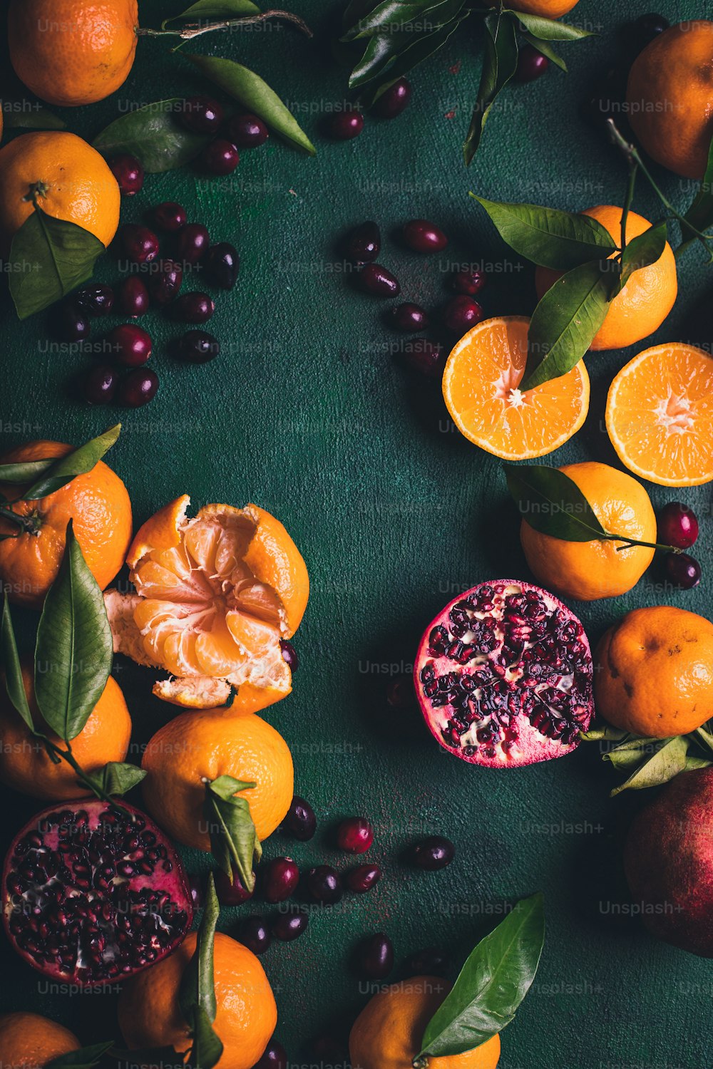 a table topped with oranges and pomegranates