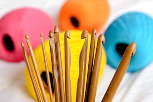 a close up of some knitting needles in a cup