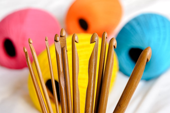 wooden knitting needles in a cup with yarn
