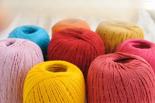a group of balls of yarn sitting on top of a bed