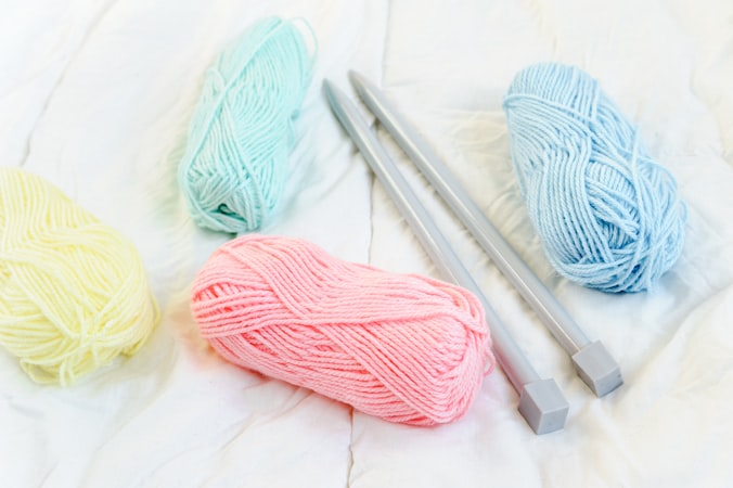 yarn skeins on bed with crochet hook