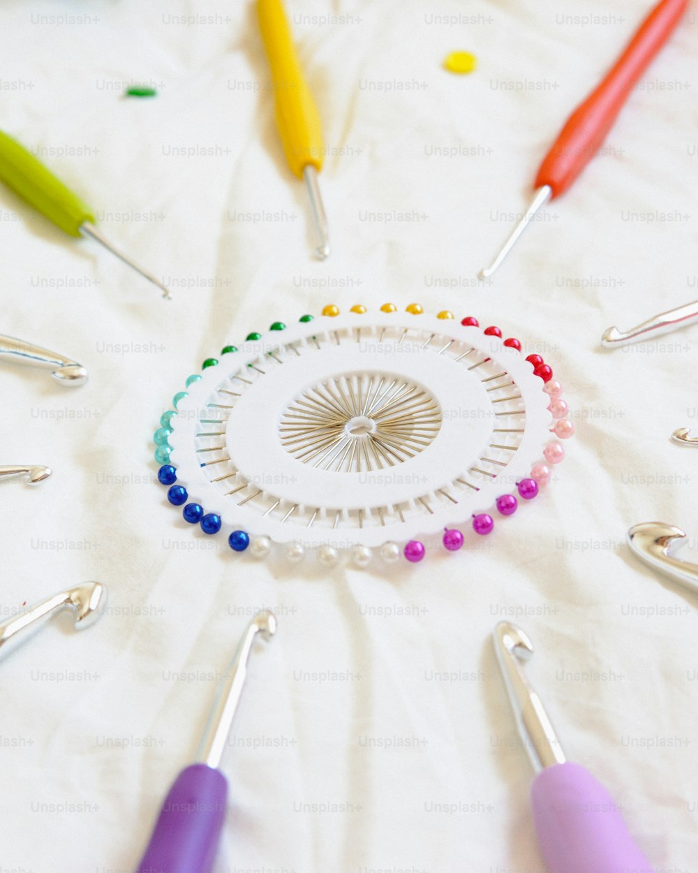 um grupo de ganchos de crochê e agulhas dispostos em círculo