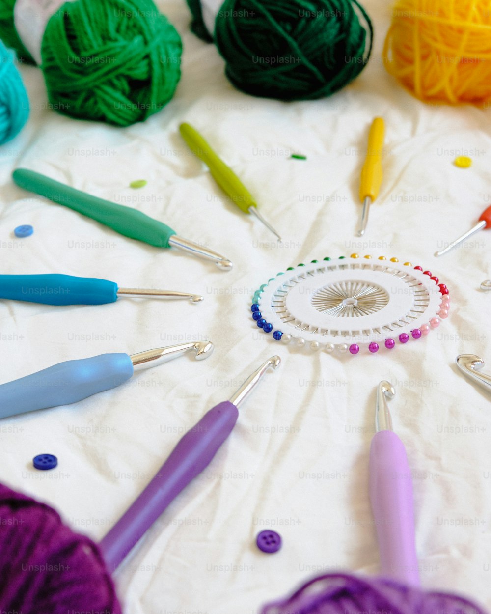 uma mesa coberta com muitos ganchos de crochê de cores diferentes