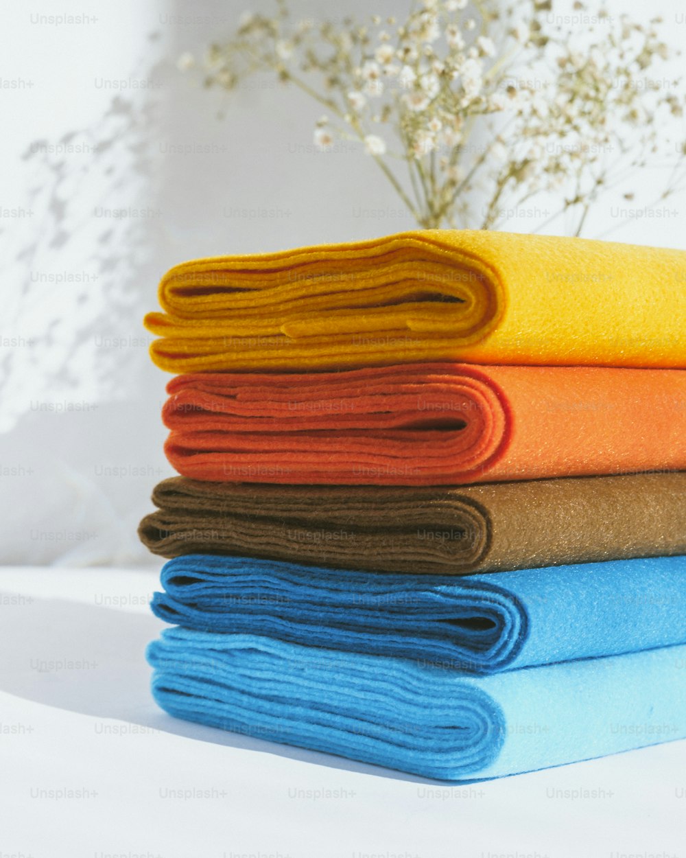una pila di asciugamani piegati seduti sopra un letto