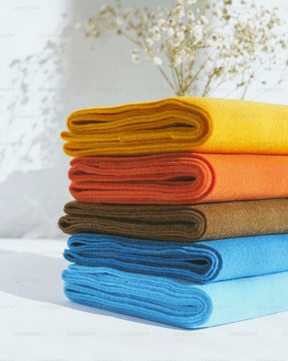 a stack of folded towels sitting on top of a bed