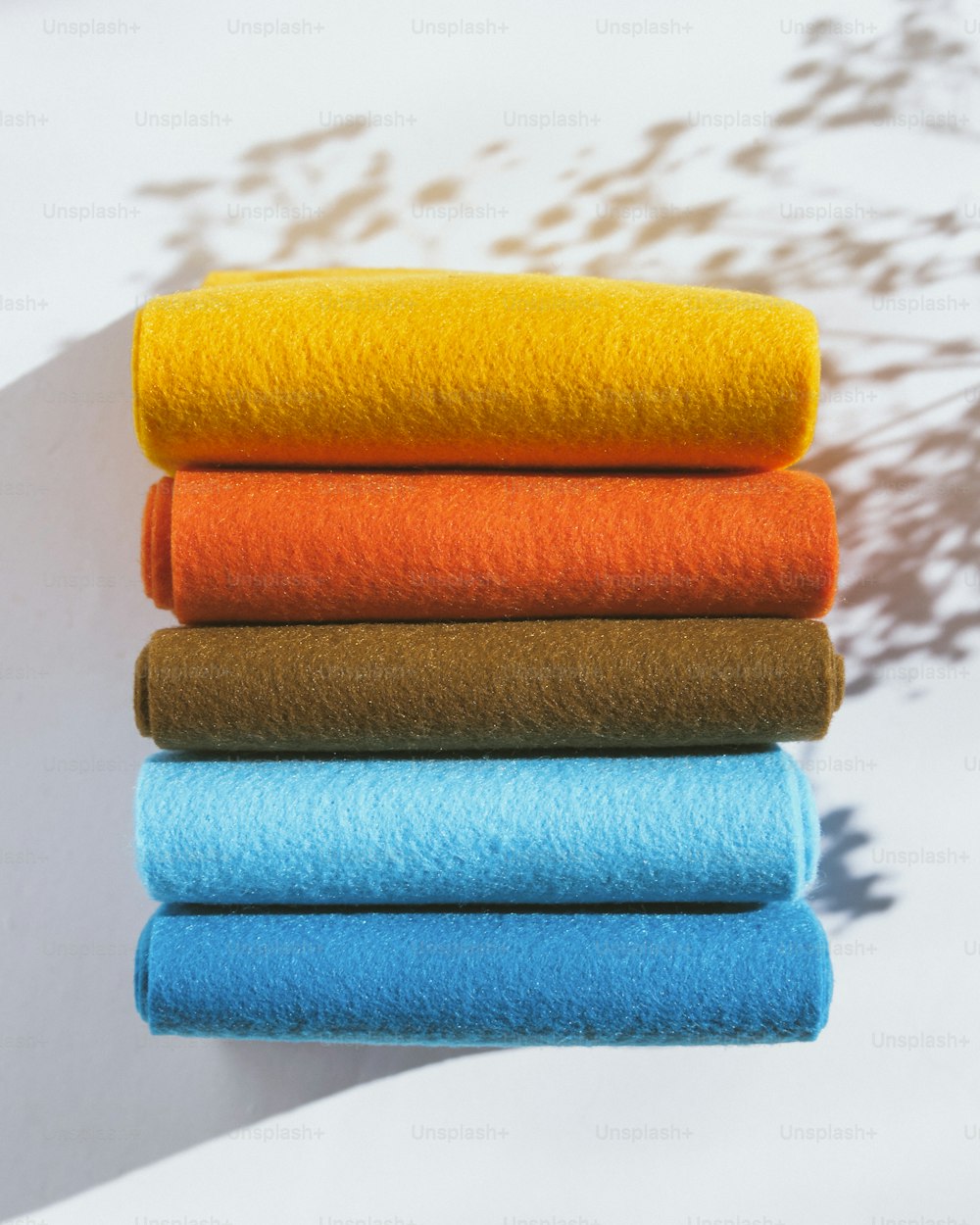 a stack of different colored towels on top of each other