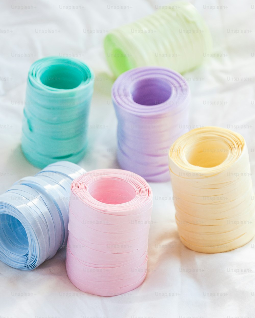 a group of different colored spools of thread